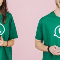 primo-piano-di-uomo-felice-e-donna-che-tengono-il-telefono-cellulare che indossa maglietta con logo whatsapp