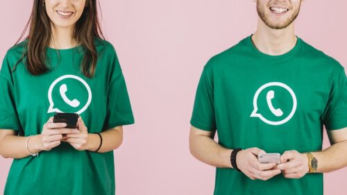 primo-piano-di-uomo-felice-e-donna-che-tengono-il-telefono-cellulare che indossa maglietta con logo whatsapp
