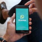uomo con smartphone aperto su whatsapp
