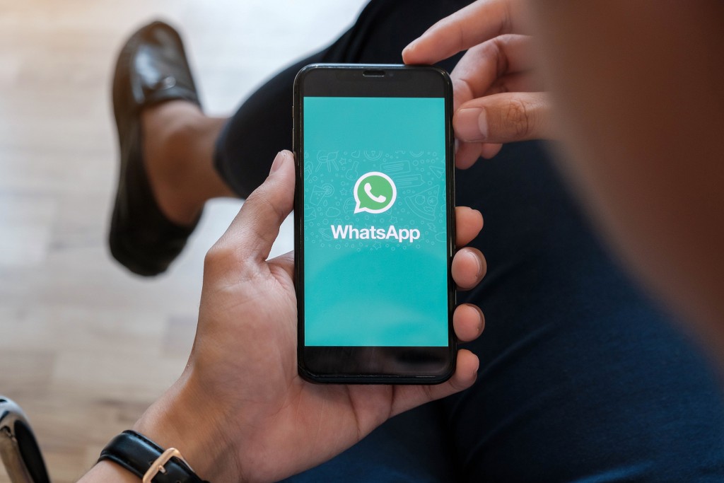 uomo con smartphone aperto su whatsapp